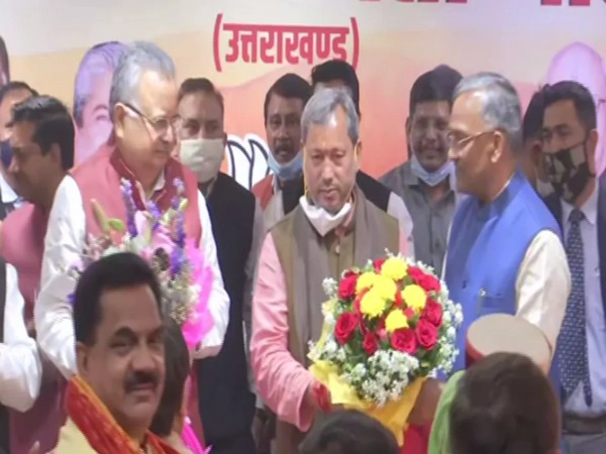 Tirath Singh Rawat flanked by former Uttarakhand CM Trivendra Rawat and other BJP leaders
