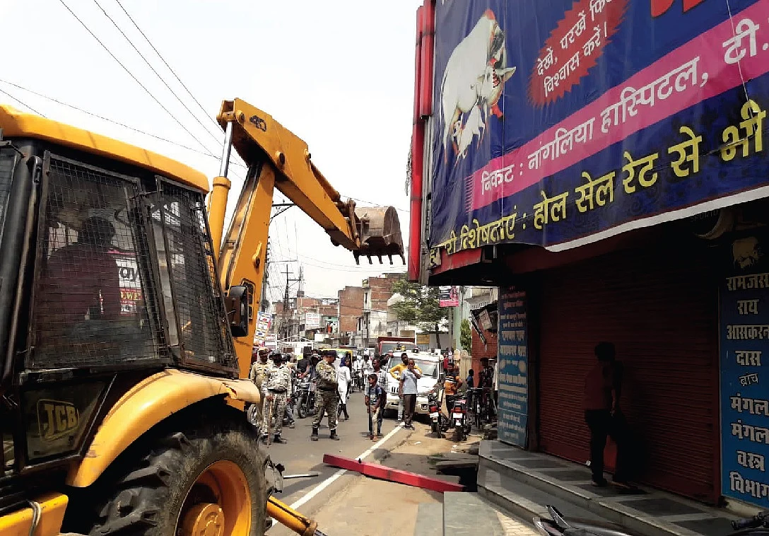 गोरखपुर में अतिक्रमण विरोधी अभियान के दौरान पुलिस ने एक व्यापारी को पकड़ लिया। जहां कार्रवाई
हो रही थी, वह दुकान बड़े कपड़ा कारोबारी शम्भु शाह के परिवार की है। शम्भु शाह ने ही योगी आदित्यनाथ के दोबारा मुख्यमंत्री बनने के बाद गोरखनाथ मंदिर पहुंचकर चांदी का बुलडोजर गिफ्ट किया था।