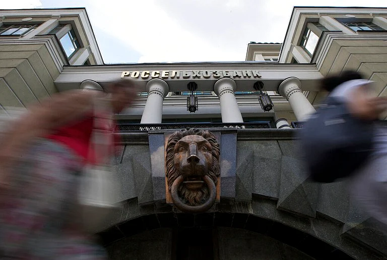 People walk past the headquarters of Russian Agricultural Bank in downtown Moscow, Russia, on July 30, 2014. It was one of the Russian banks hit by Western sanctions. (AP Photo)