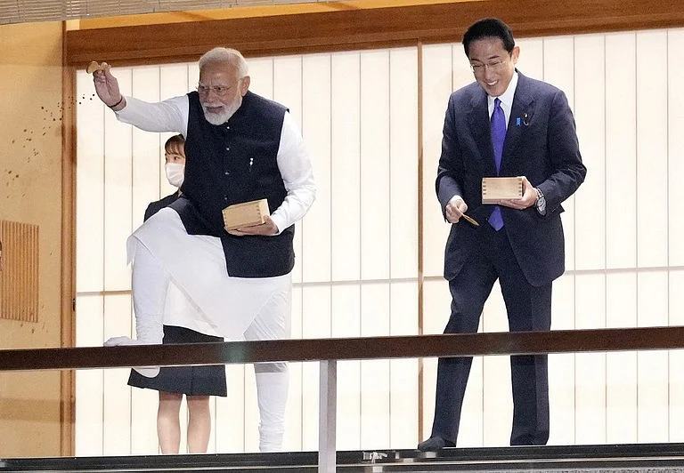 Indian Prime Minister Narendra Modi (L) and Japanese Prime Minister Fumio Kishida feed carp before their dinner at Akasaka State Guest House in Tokyo on May 24, 2022, following the end of the Quad leaders' summit between the US, Japan, India and Australia.