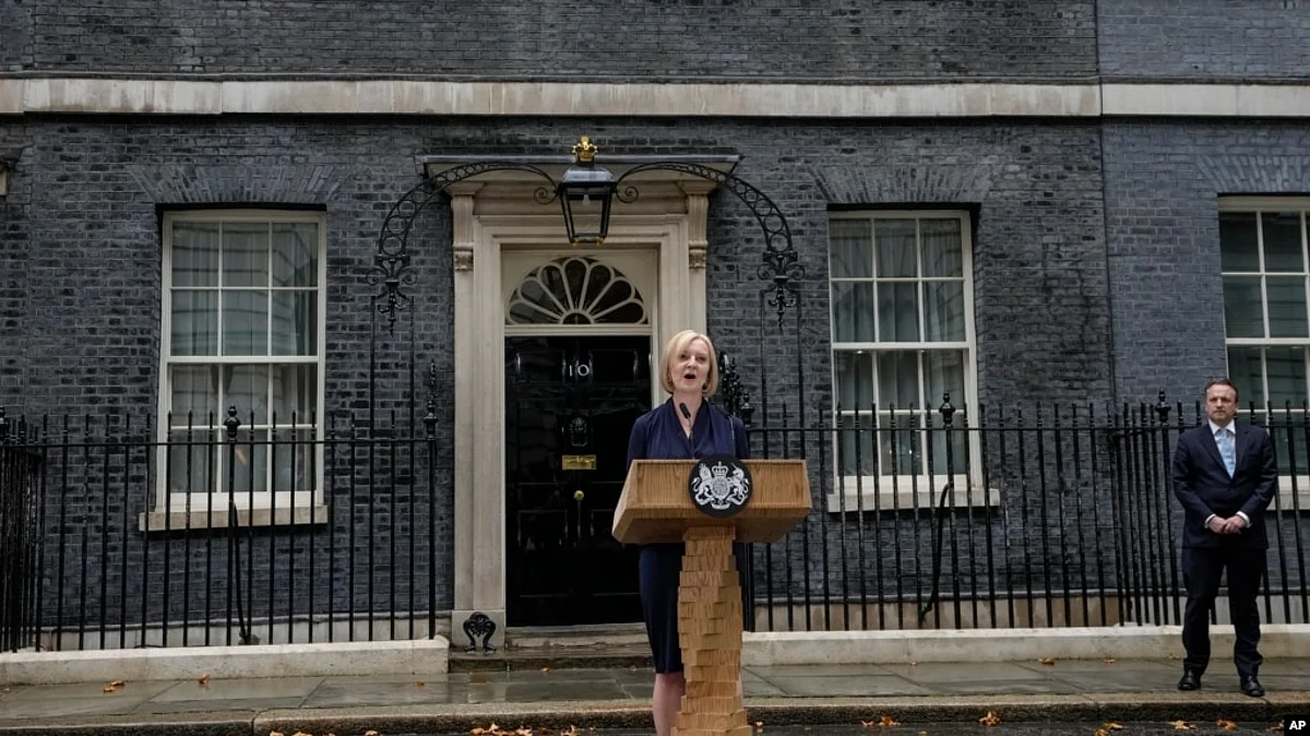 New British Prime Minister Liz Truss speaks outside Downing Street as her husband, Hugh O'Leary, listens, in London, Sept. 6, 2022 after returning from Balmoral in Scotland where she was formally appointed by Britain's Queen Elizabeth II. (AP via VOA)
