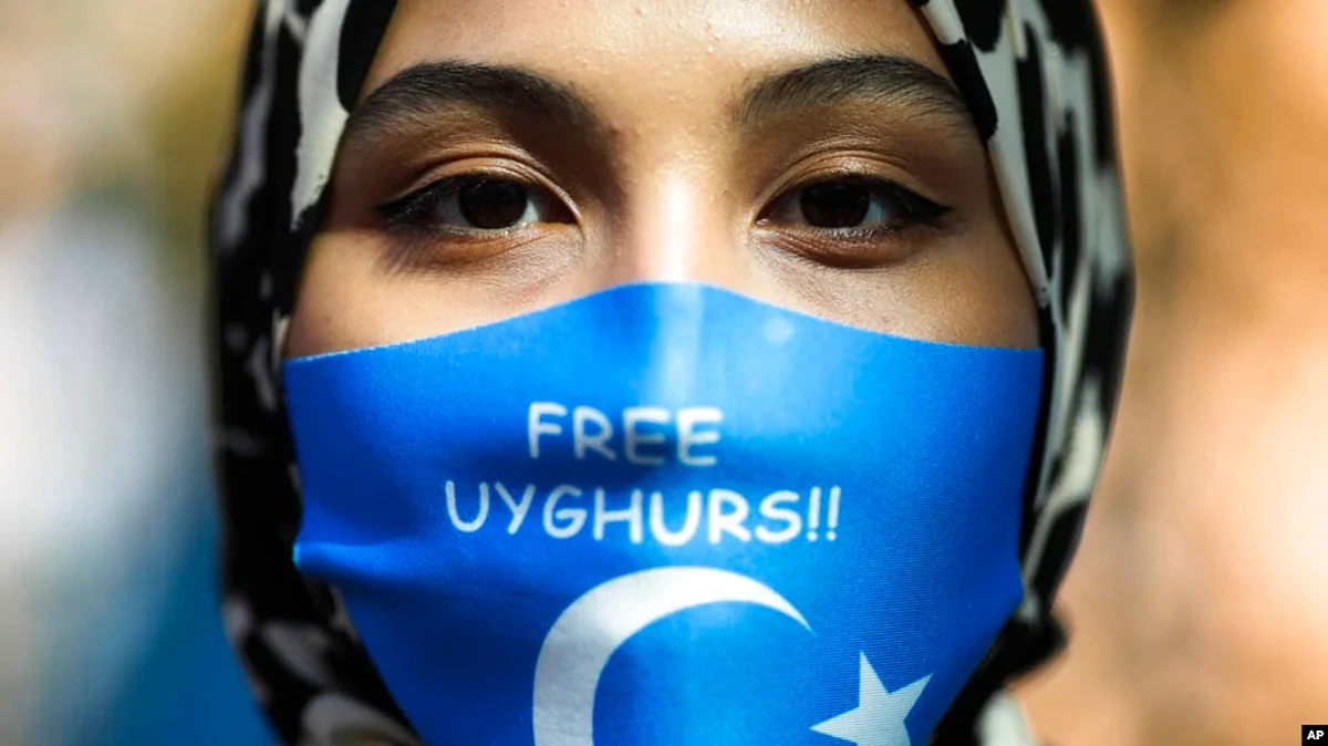 A woman wears a mask reading "Free Uyghurs" at a protest during the visit of Chinese Foreign Minister Wang Yi in Berlin, Sept. 1, 2020. In the U.S., the Biden administration called on China on Sept. 1, 2022, to stop “atrocities” against Uyghurs and other ethnic minorities.