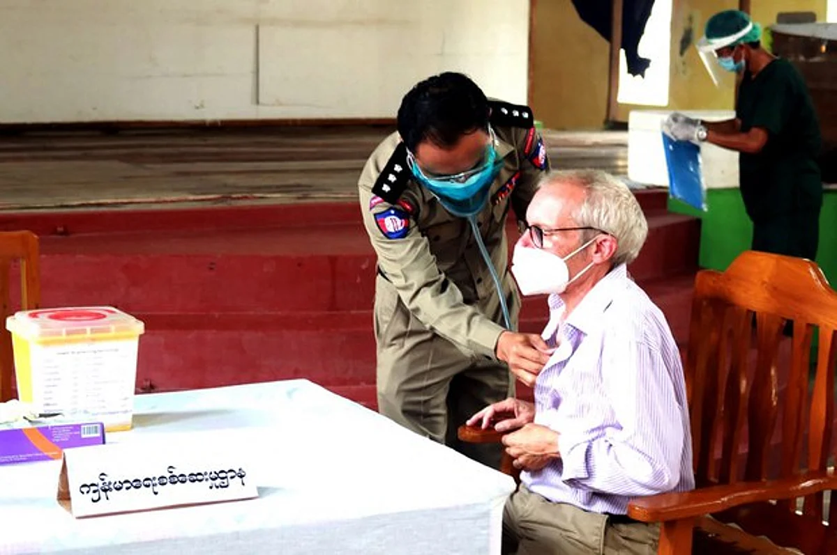 This handout photo from the state-run Myanmar News Agency (MNA) taken on July 28, 2021, and received on July 29 shows Sean Turnell, a detained Australian adviser to Myanmar's deposed leader Aung San Suu Kyi, getting vaccinated against the Covid-19 coronavirus in Insein prison in Yangon.