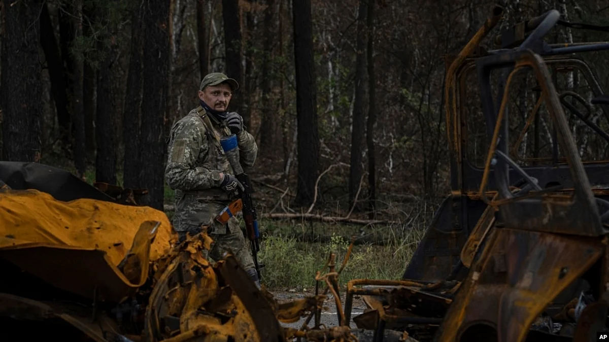 Russia-Ukraine War: A Ukrainian serviceman walks along a road while searching for the dead bodies of his comrades killed in the recently recaptured town of Lyman on October 3.