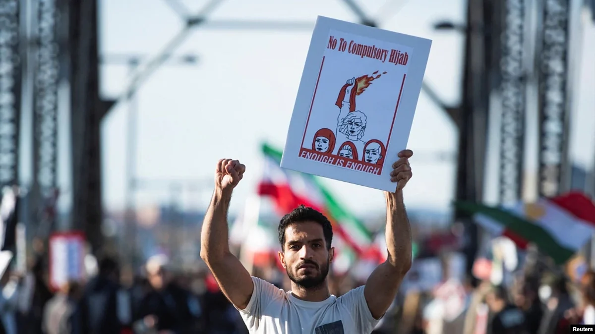A protestor holds a banner during a protest in support of women in Iran.
