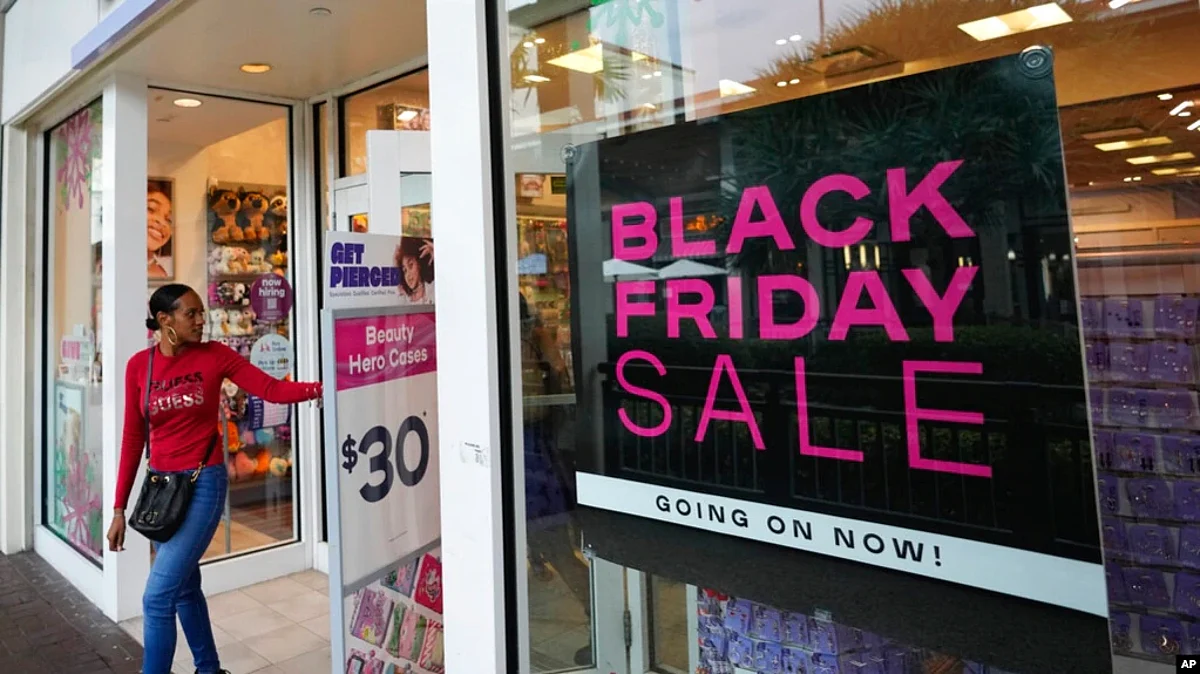 Shoppers exit a Claire's accessories store advertising sales ahead of Black Friday and the Thanksgiving holiday, Nov. 21, 2022, in Miami.