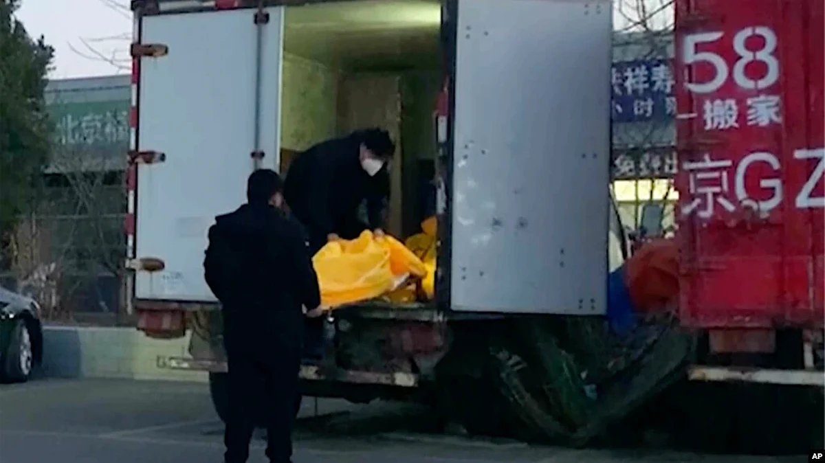 Workers load body bags into a truck at a funeral complex in Beijing, Dec. 16, 2022. (AP)