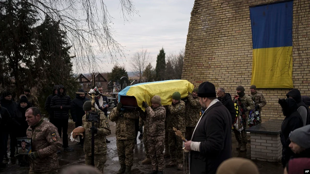 Ukrainian soldiers carry the coffin of Dmytro Kyrychenko near Kyiv, Ukraine, Dec. 23, 2022. Upon returning to Kyiv after visiting the U.S., Ukraine President Volodymyr Zelenskyy said Ukrainian forces “are working toward victory” despite Russia’s relentless attacks on the country. (AP)