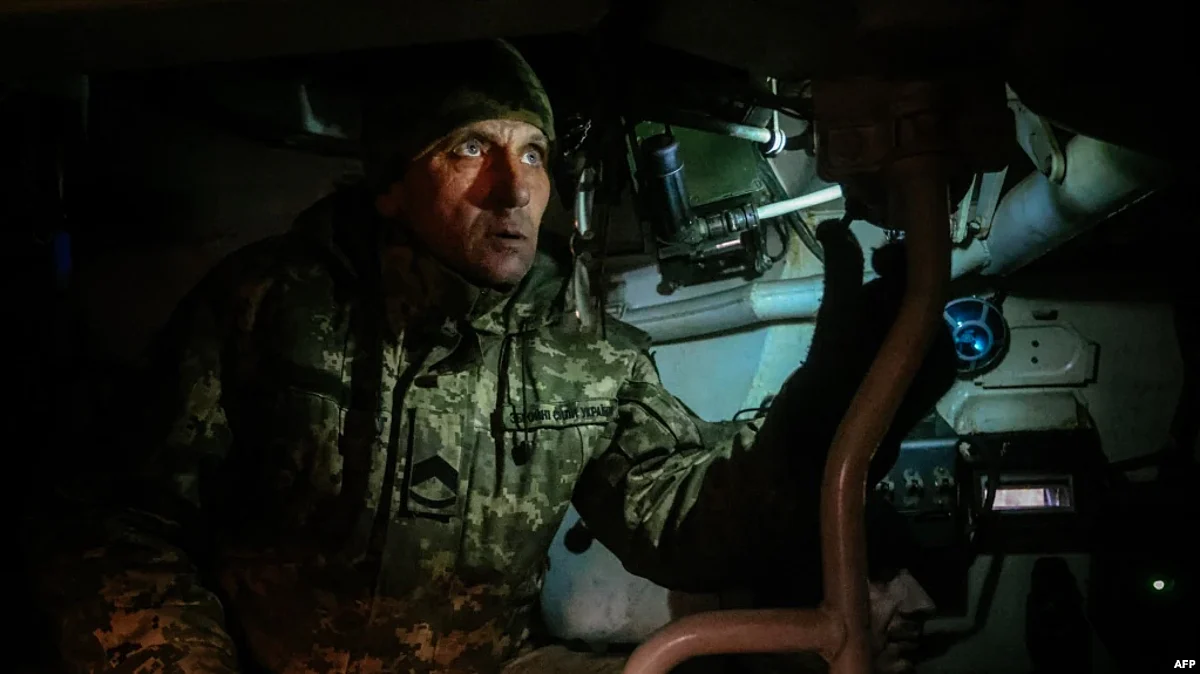 A Ukrainian artilleryman looks through a periscope of a self-propelled howitzer towards Russian positions in a field near an undisclosed frontline position in eastern Ukraine, Nov.30, 2022. (AFP)