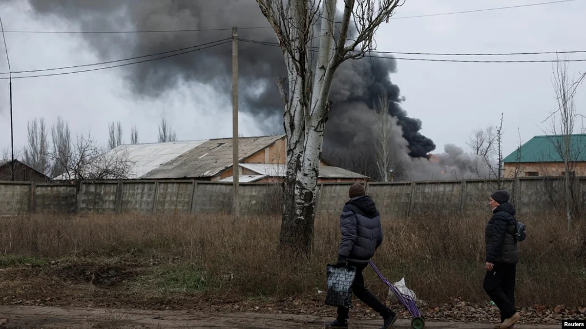 Volodymyr, 61, and Nataliia Bolias, 51, walk past an industrial building that received a missile strike, as Russia's attack on Ukraine continues, during intense shelling on Christmas Day at the frontline in Bakhmut, Ukraine, Dec. 25, 2022. (Reuters)