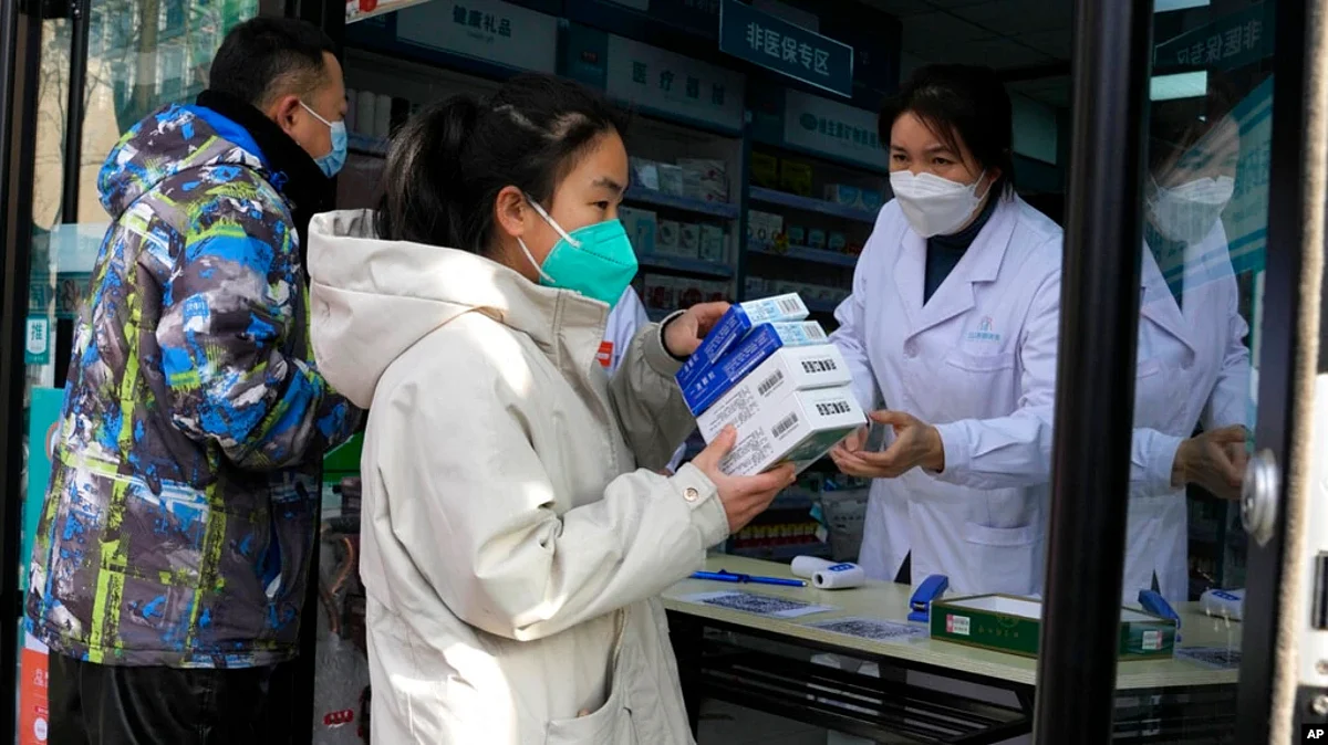 A resident carries away medicine bought at a pharmacy in China, Dec. 9, 2022. (AP)