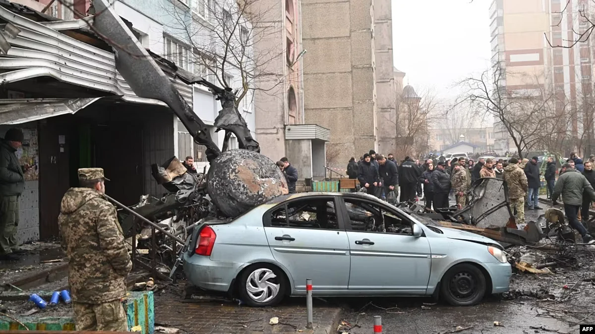Military and onlookers stand at the site where a helicopter crashed near a kindergarten outside the capital Kyiv, killing eighteen people, including three children and the Ukrainian interior minister, on Jan. 18, 2023, amid the Russian invasion of Ukraine. (AFP)