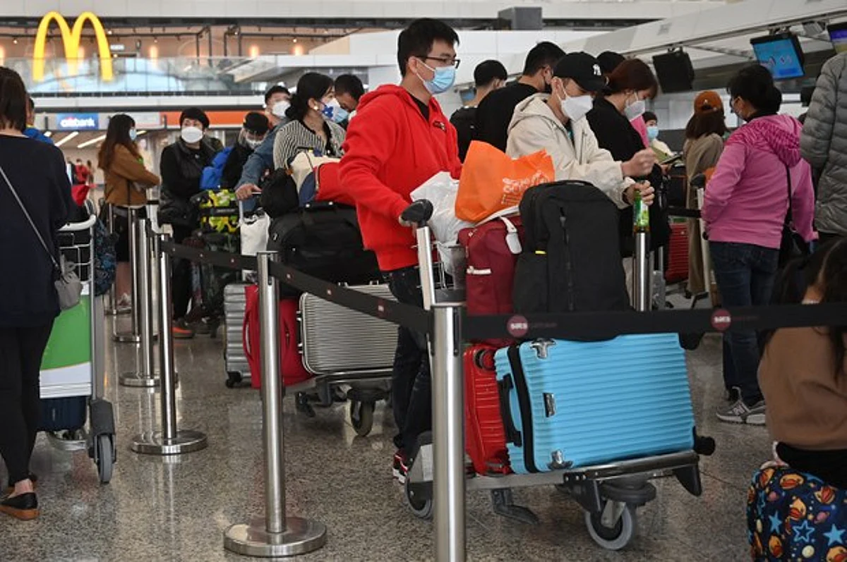 Passengers queue to check-in at the international airport in Hong Kong on Dec. 28, 2022. (AFP)
