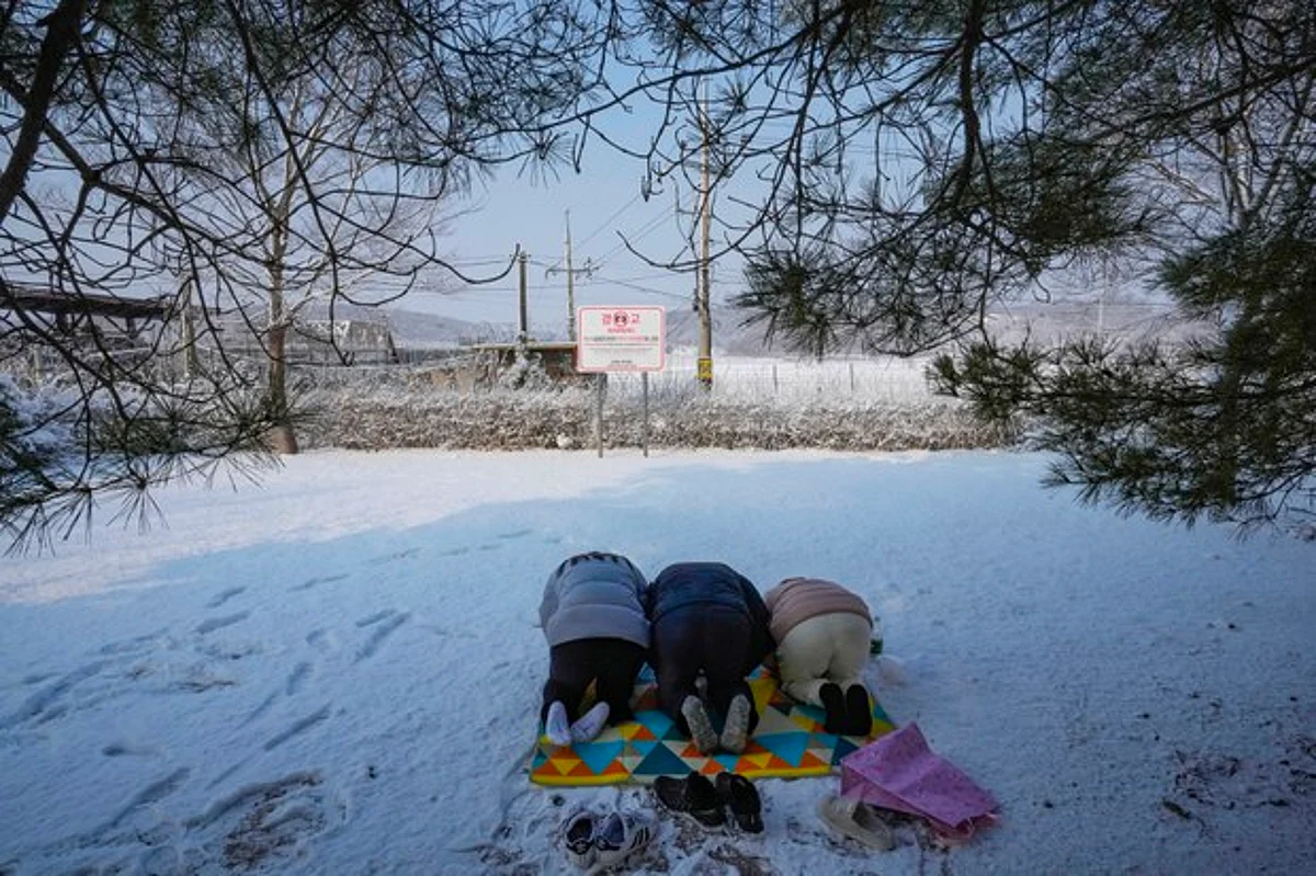 North Korean refugees and their family members bow to respect for their ancestors as they visit the Imjingak Pavilion near the border with North Korea, to celebrate the Lunar New Year in Paju, South Korea, Tuesday, Feb. 1, 2022. (AP Photo/Ahn Young-joon)