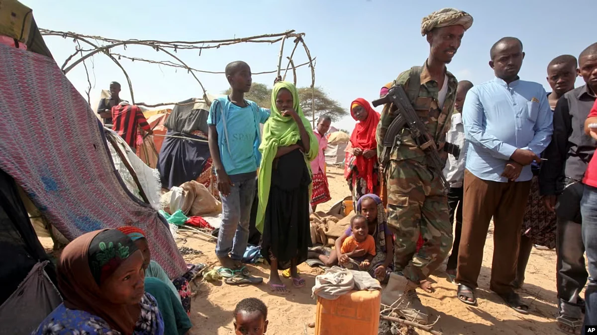 FILE - Somalia Conflict takes toll on civilian mental health. A Somali soldier provides security as newly displaced Somalis gather at a camp on the outskirts of Mogadishu, Somalia, March 28, 2017. (AP)