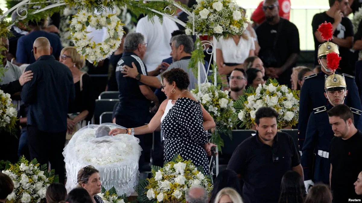 Pele's daughter, Kelly Cristina Nascimento, is seen next to the body of Brazilian soccer legend Pele in his casket, as he lays in the state on the pitch of his former club Santos' Vila Belmiro Stadium in Santos, Jan. 2, 2023. (Reuters)