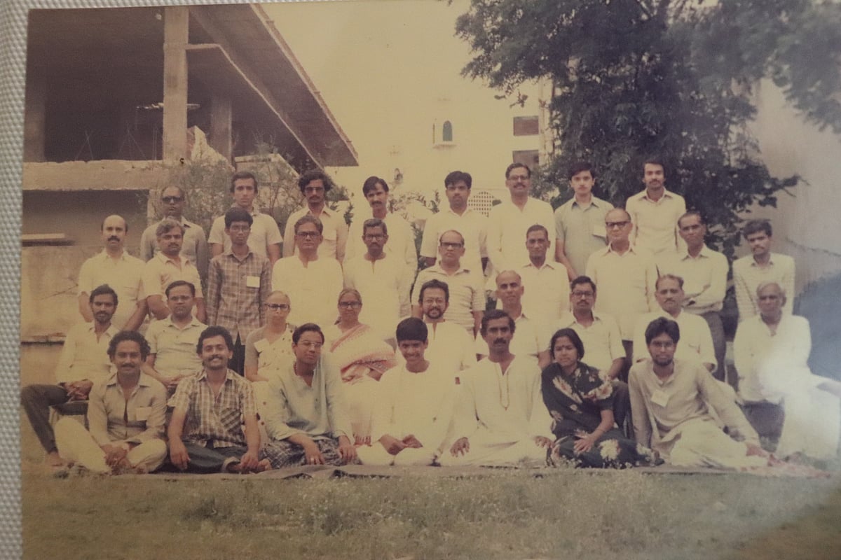 वासुदेव जमीन पर बैठे हैं, दायें से तीसरे स्थान पर हैं।