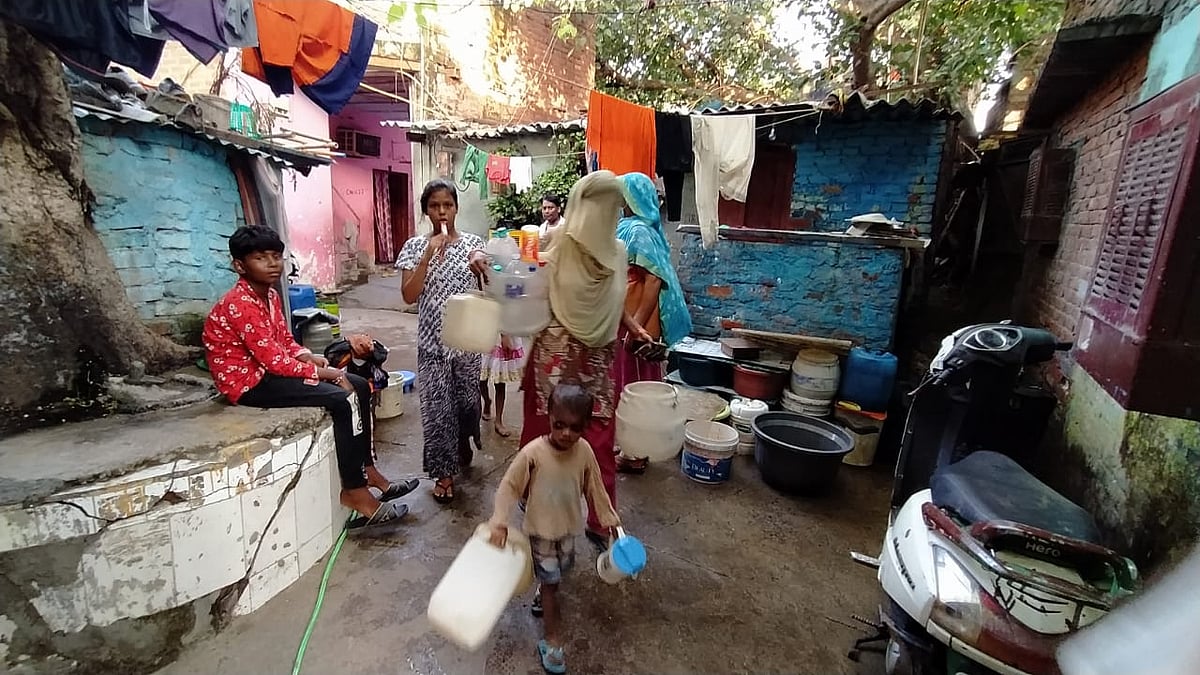 अन्ना नगर झुग्गी में पानी भरने जाती एक महिला