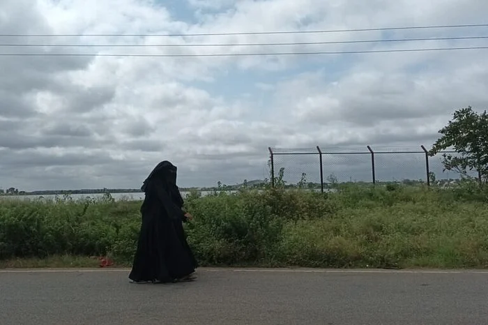 चिकबल्लापुर में मस्तूर झील के पास से गुजरती एक महिला.