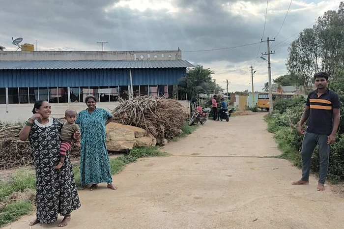 बाईं ओर खड़ी चंद्रम्मा और उनका बेटा विनय जो कि सोमांबुदी झील के पास रहते हैं. यह बेंगलुरु के गंदे पानी को कोलार में लाने वाली झीलों में से एक है. ये लोग यहां के भूजल की गुणवत्ता से नाखुश हैं क्योंकि उन्हें पीने और सिंचाई के लिए गंदा पानी मिल रहा है. 