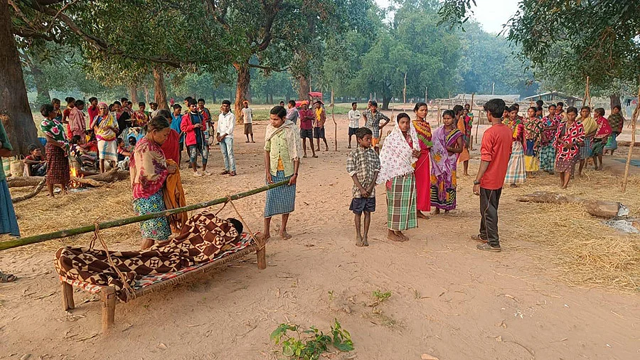 An injured Sonu being transported by villagers in a charpoy.
