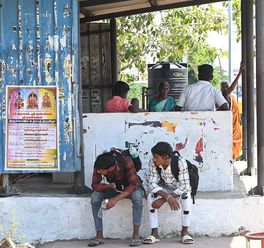 Workers rest outside a tea shop, sharing a bottle of water – their only relief from the heat in Dindigul, Tamil Nadu. 
