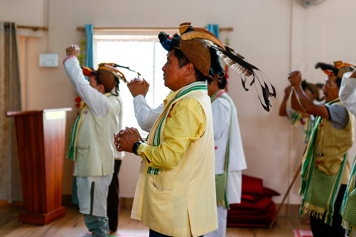 Followers of Donyi Polo, an indigenous faith, wait to receive a sacred offering in Doimukh, Arunachal Pradesh. Once an oral, animist tradition, the revivalist faith now mirrors elements of both Hinduism and Christianity