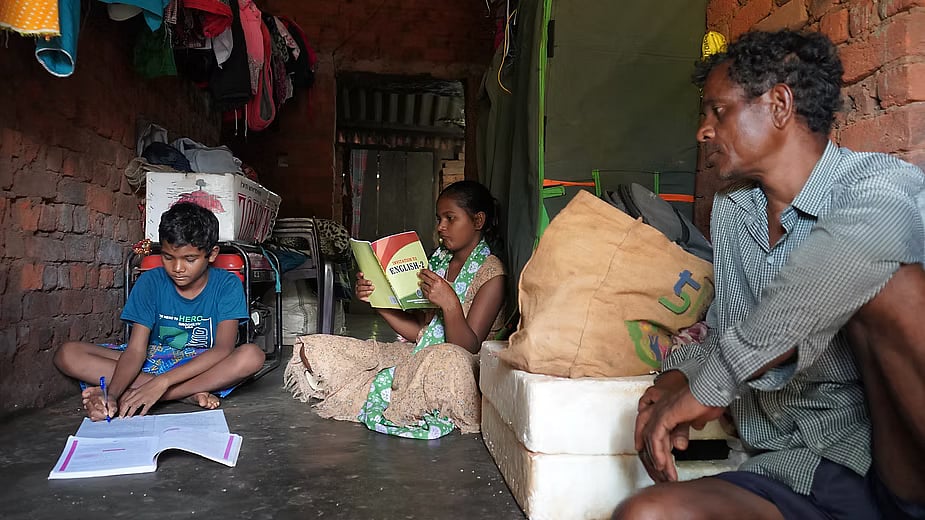 Dana Majhi with his youngest son and only daughter at their home in Dhamanguda village which is filled with sound systems and other equipment as the family builds an entertainment business. Photo: Prajjwal Thakur