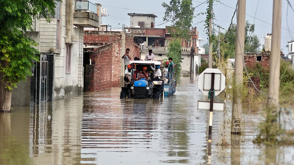 बाढ़ के पानी के बीच मदद पहुंचाने जाते लोग