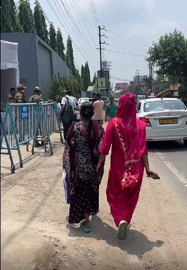 People walking past a barricade outside the appellate tribunals. 