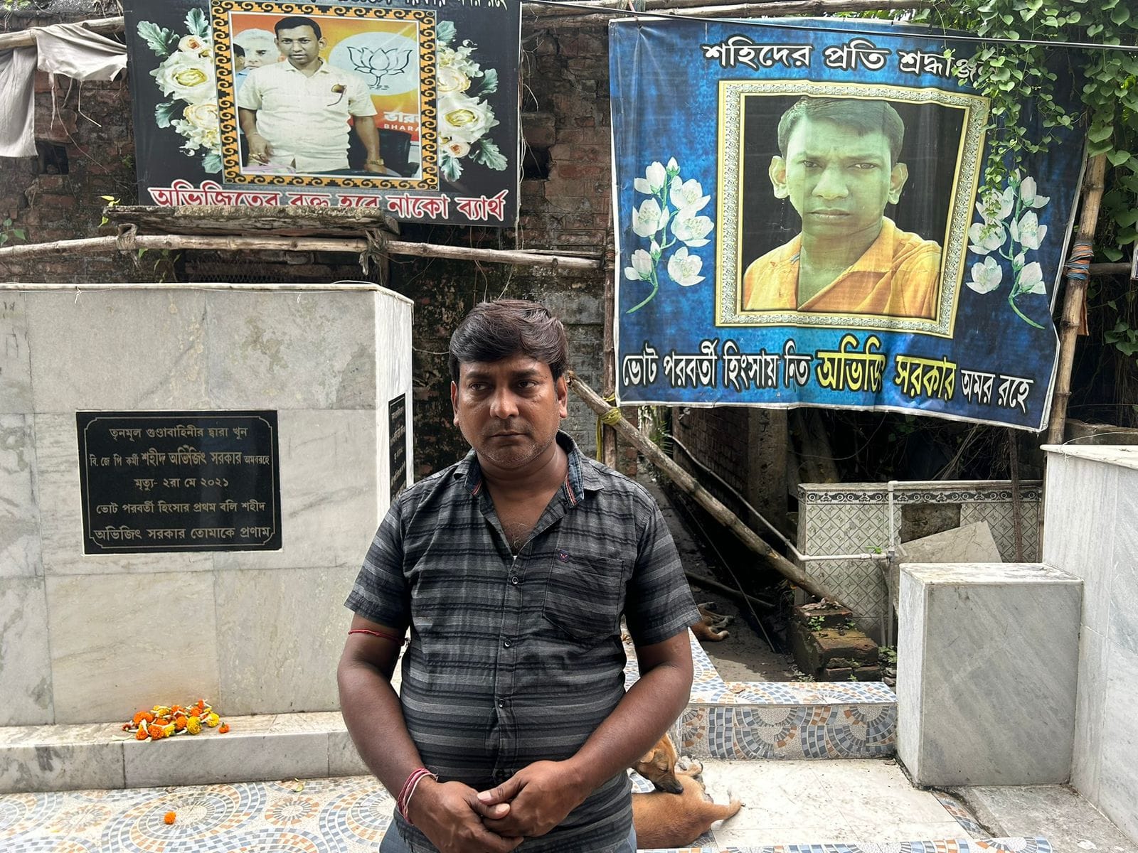 Abhijit Sarkar's brother standing in front of a memorial built for him. Abhijit was killed in 2021 in post-poll violence.