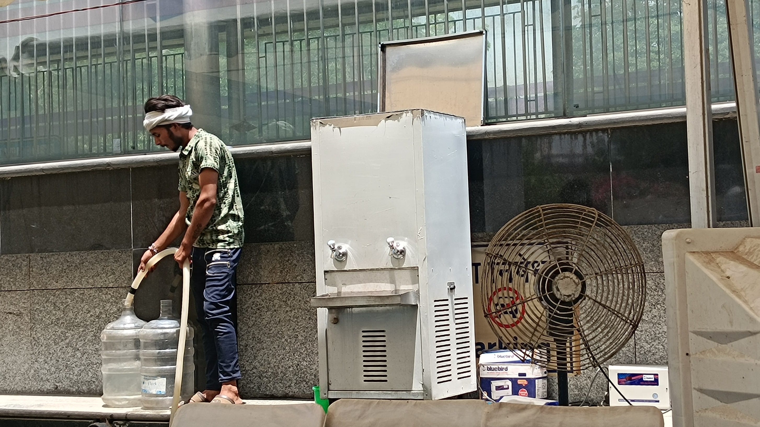 Sachin fills cans with water from the Delhi Jal Board tanker.