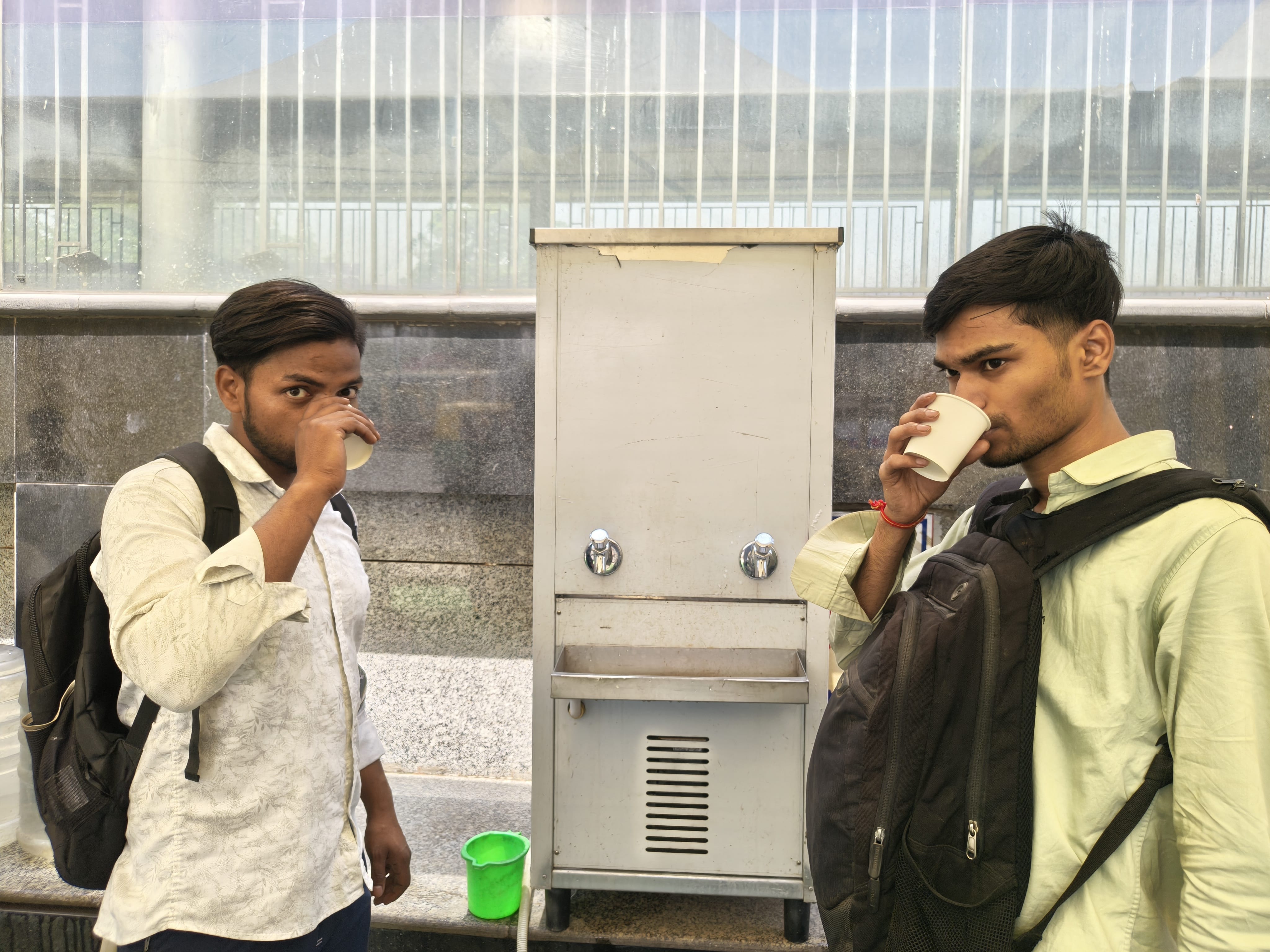 People are drinking water from a dispenser inside the cooling zone.
