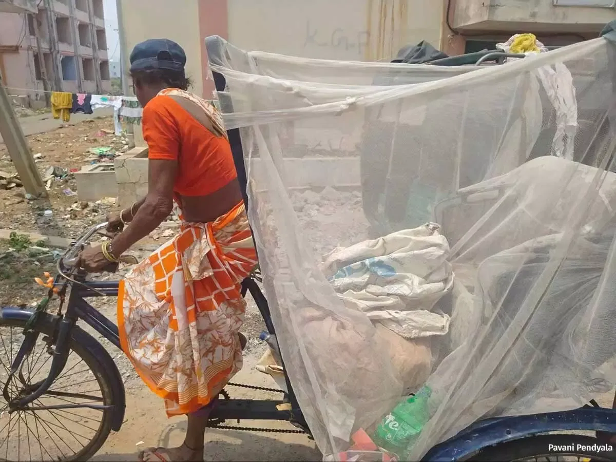 Waste picker working outdoors during the summer in New Raja Rajeshwari Peta.