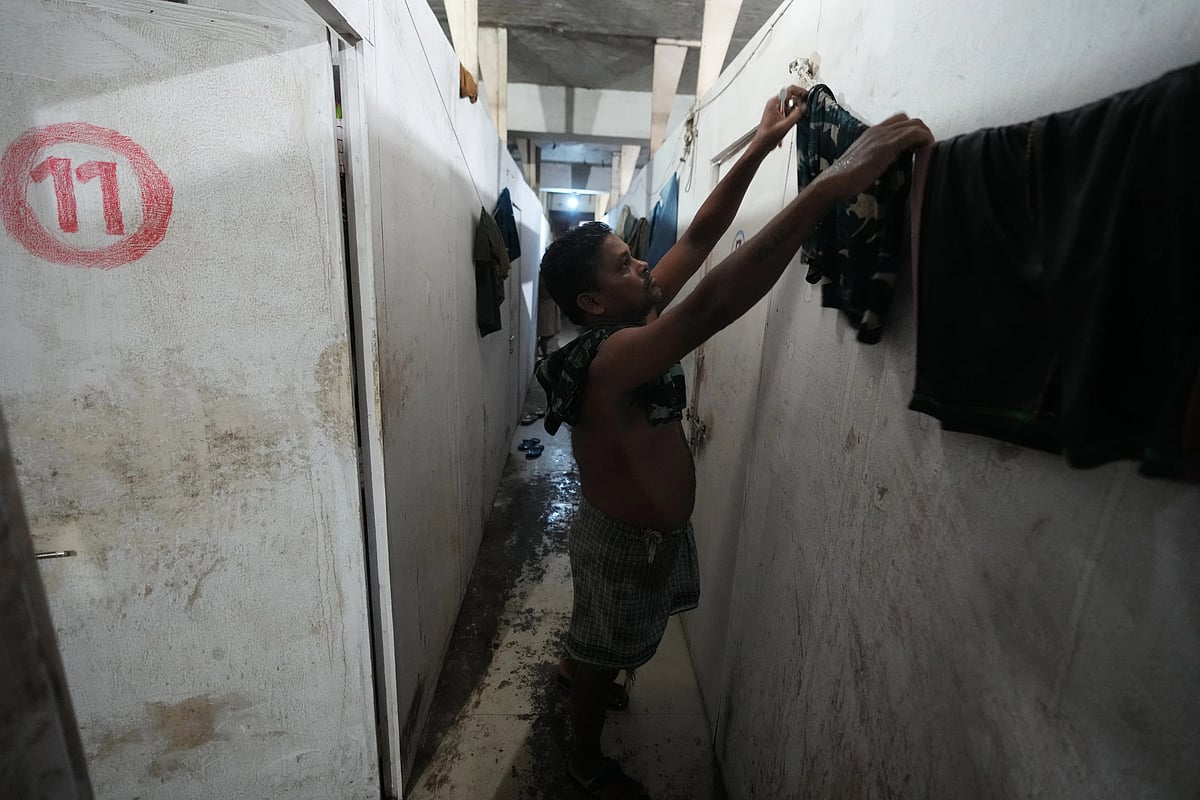 Sibaram Pradhan hangs clothes for drying after taking a bath. (AP Photo/Ajit Solanki)