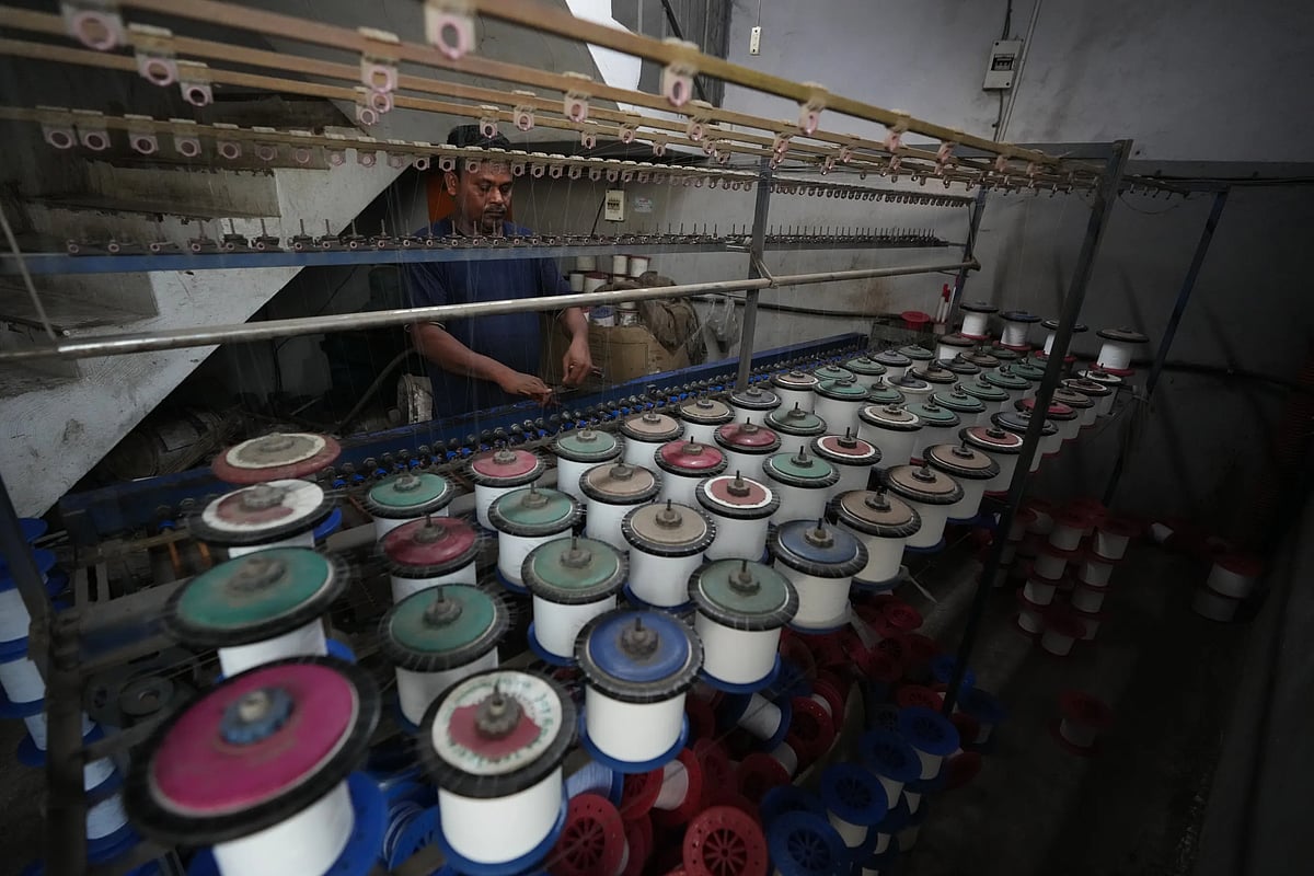 Sibaram Pradhan works at a power-loom factory that produces polyester cloth at the Anjani Industrial Estate in Surat. (AP Photo/Ajit Solanki)