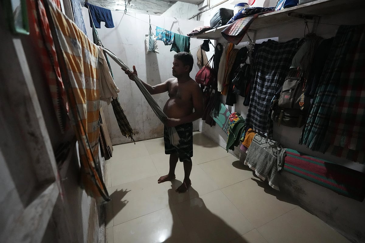 Sibaram Pradhan gets ready to take a bath after a day’s work at his residential quarters. (AP Photo/Ajit Solanki)