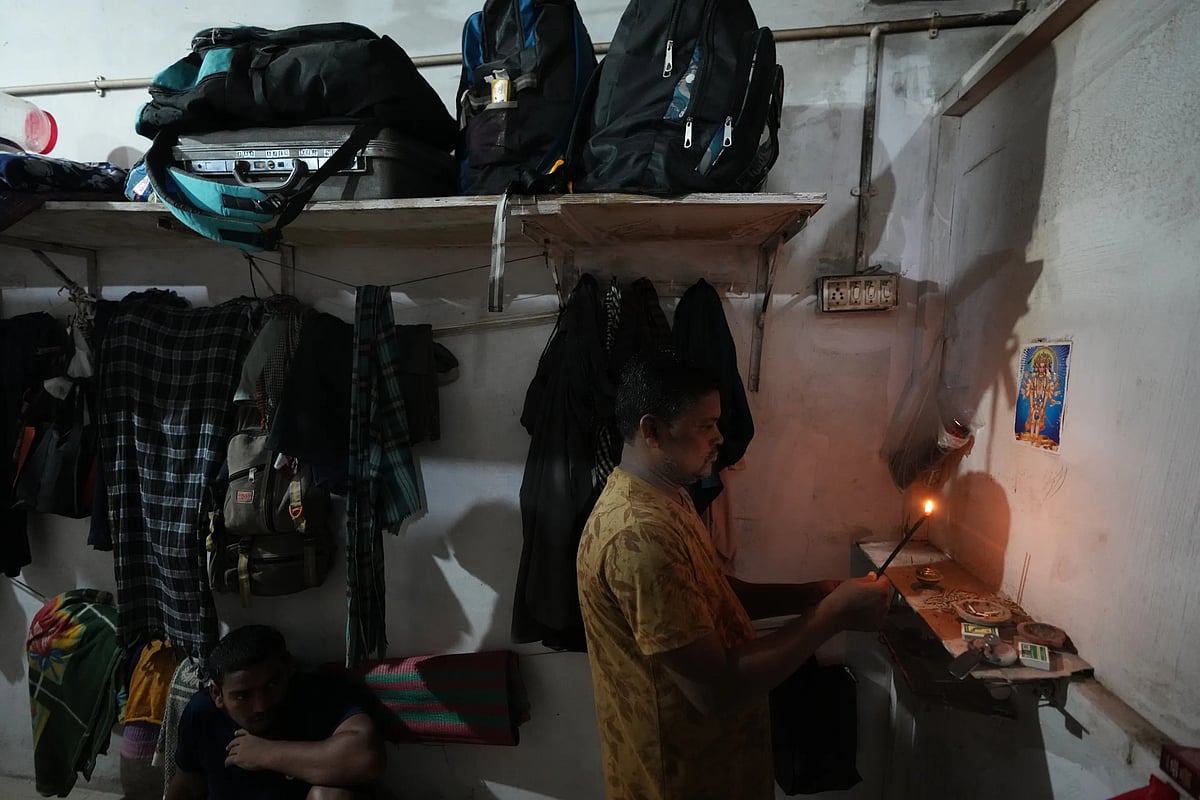 Sibaram Pradhan prays before going to work. (AP Photo/Ajit Solanki)