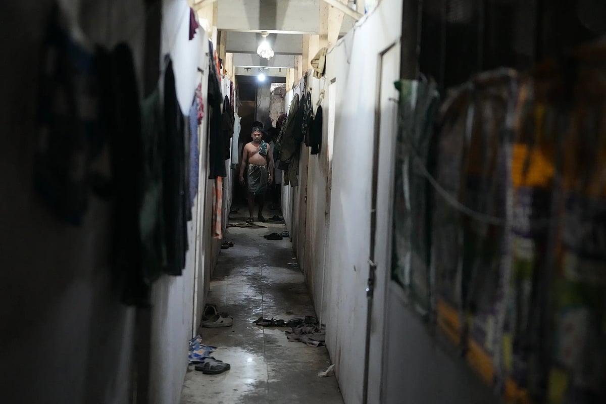Sibaram Pradhan walks down a hallway after taking a bath. (AP Photo/Ajit Solanki)