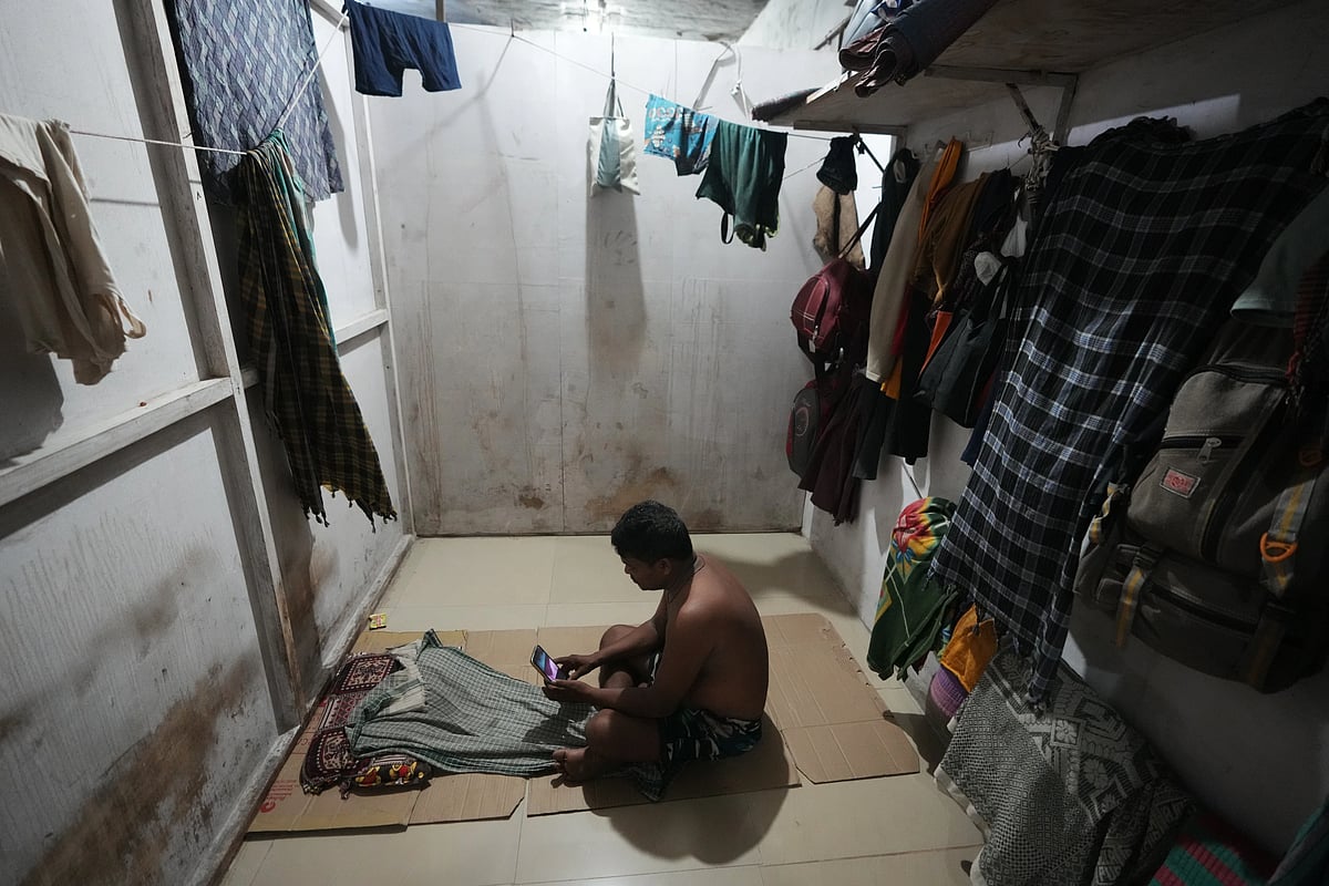 Sibaram Pradhan, a power loom factory worker, makes a video call to his family at his residential quarters in Surat. (AP Photo/Ajit Solanki)