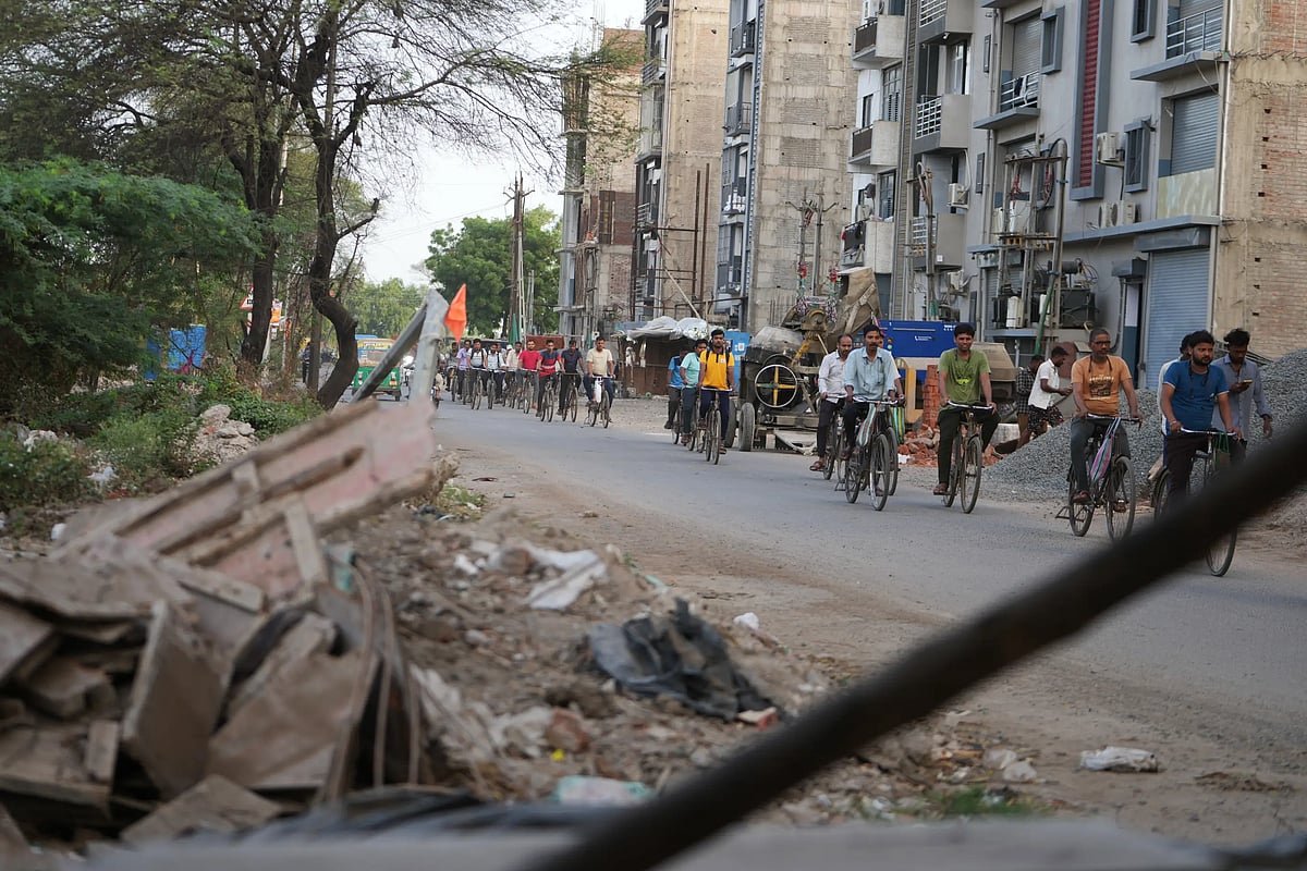 Power loom factory workers cycle to work in Surat. (AP Photo/Ajit Solanki)