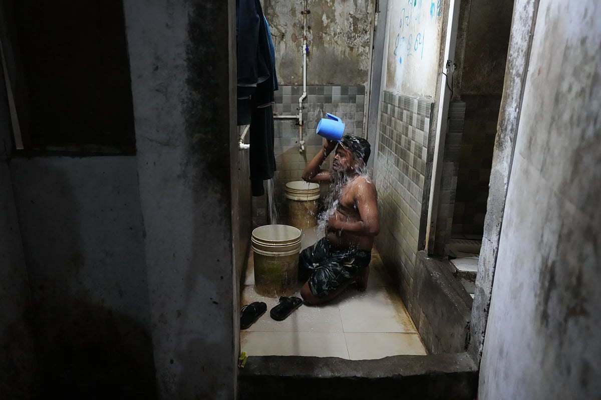 Sibaram Pradhan takes a bath after a day's work at his residential quarters. (AP Photo/Ajit Solanki)