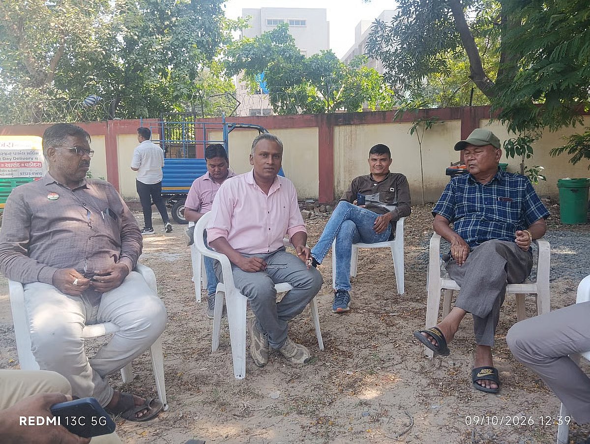 Ashwin Vaghela (in a pink shirt) at his home, with Crime Branch officers in the background.