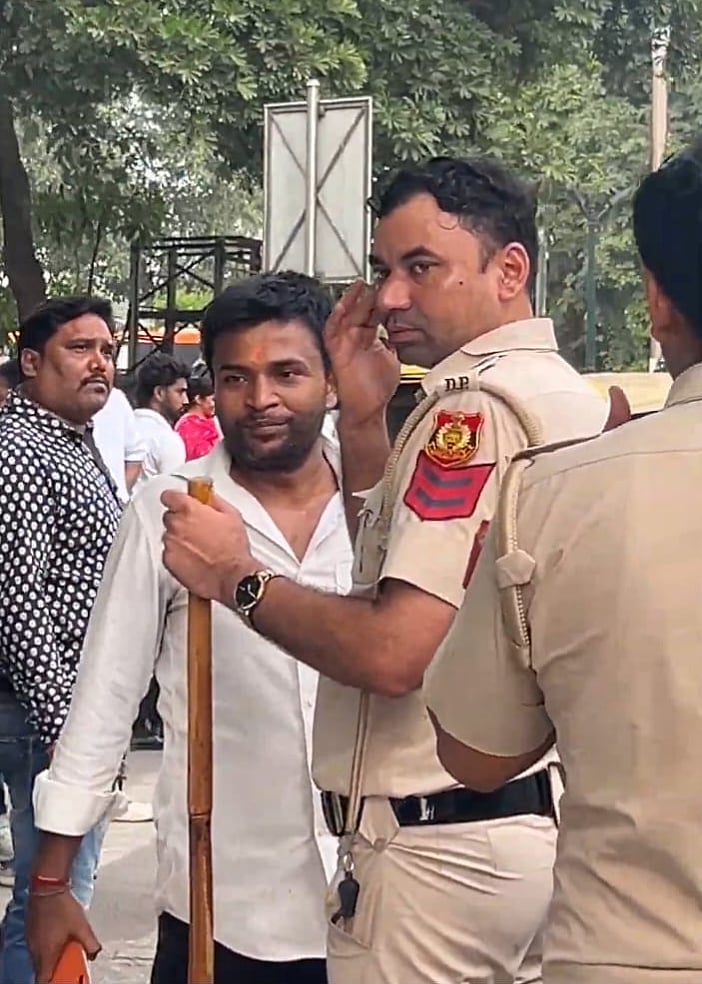 The man in the white shirt speaking to Head Constable Chandraveer Attri.