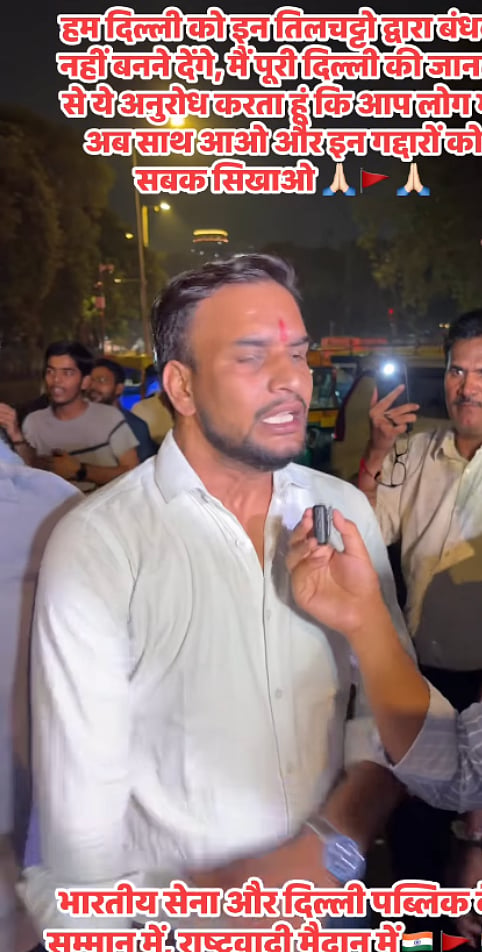 The same man can be seen here in the background in a grey T-shirt with horizontal stripes, as Dwivedi gives an interview.
