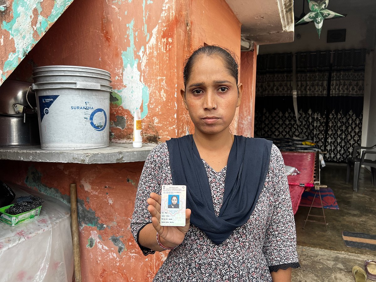 Nisha holding up her ID card