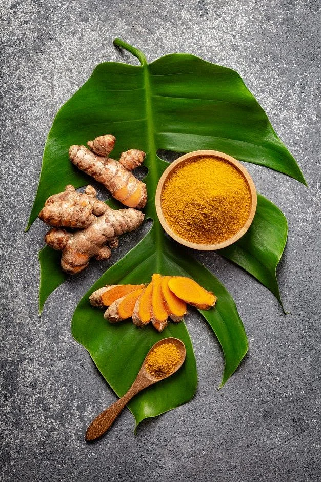 Premium Photo Turmeric powder and fresh turmeric root on grey