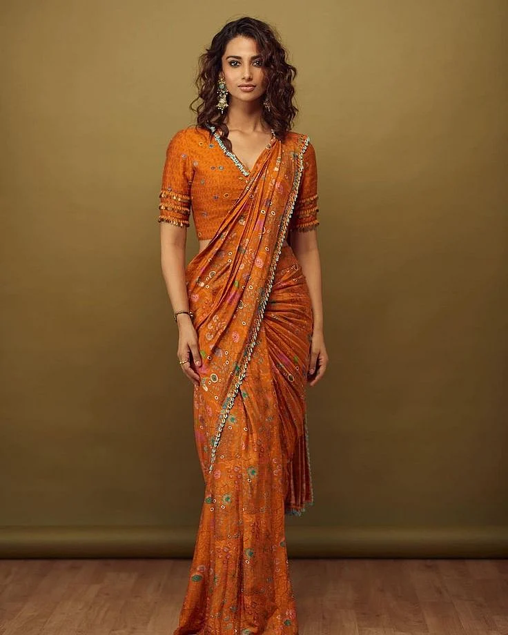 Meenakshi Chaudharys glam look in an orange pre draped saree