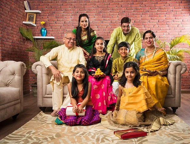Premium Photo Portrait of happy Indian family in traditional wear sitting on sofa indoor
