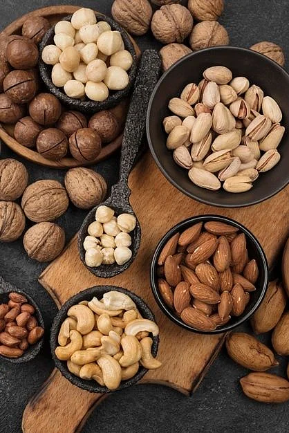 Free Photo Organic nuts snack in bowls on wooden board